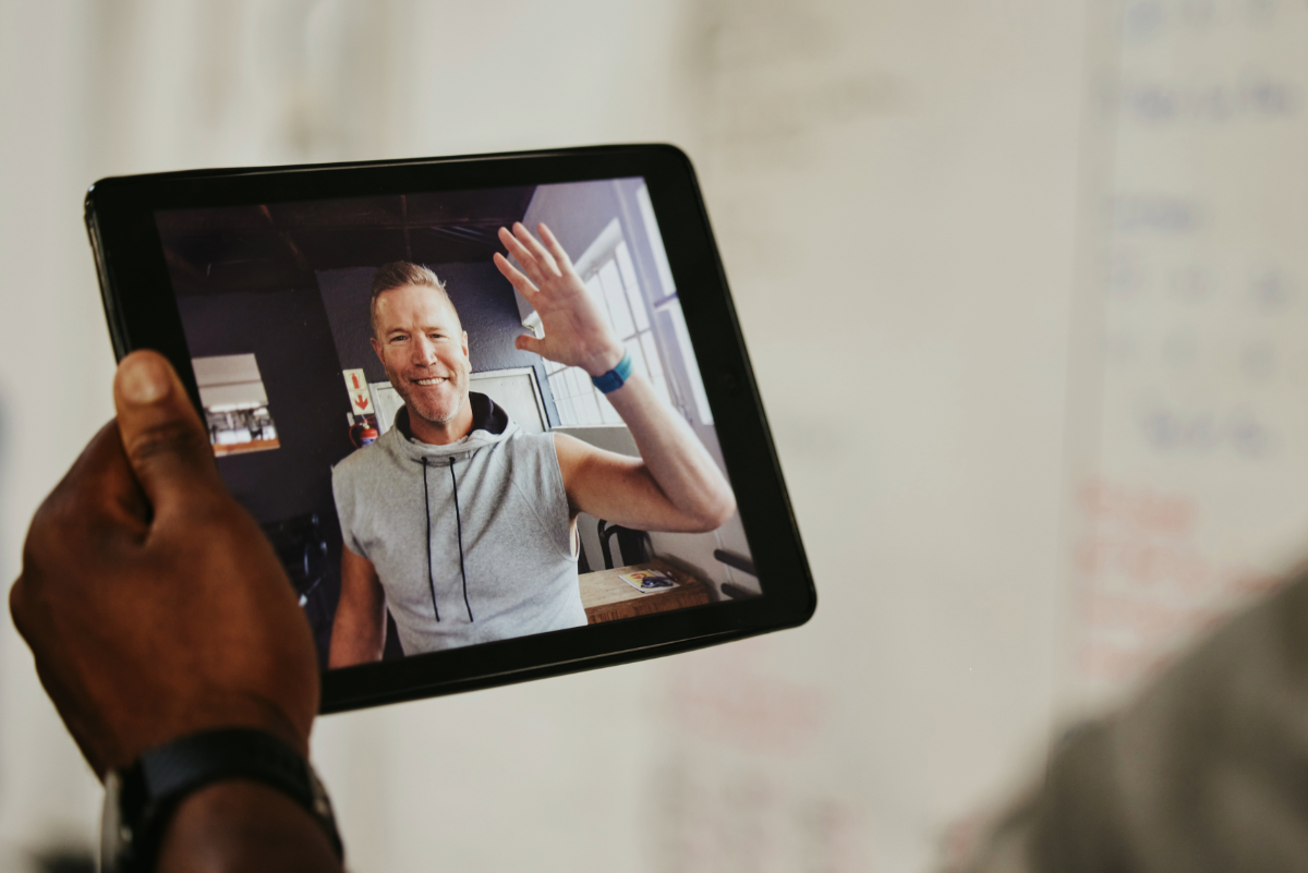 Person holding a tablet with video chat displayed on the screen