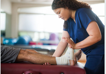 Athletic trainer assisting a person with a foot injury.